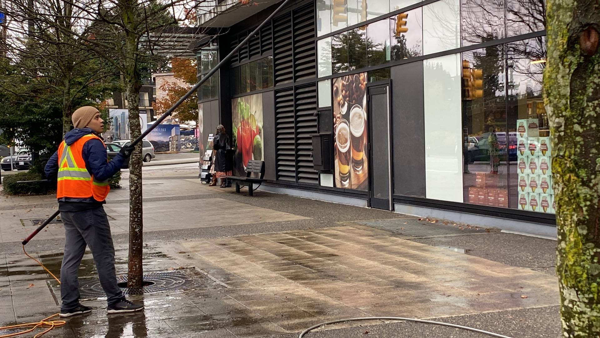 Cleaning high storefront glass with a long extension pole