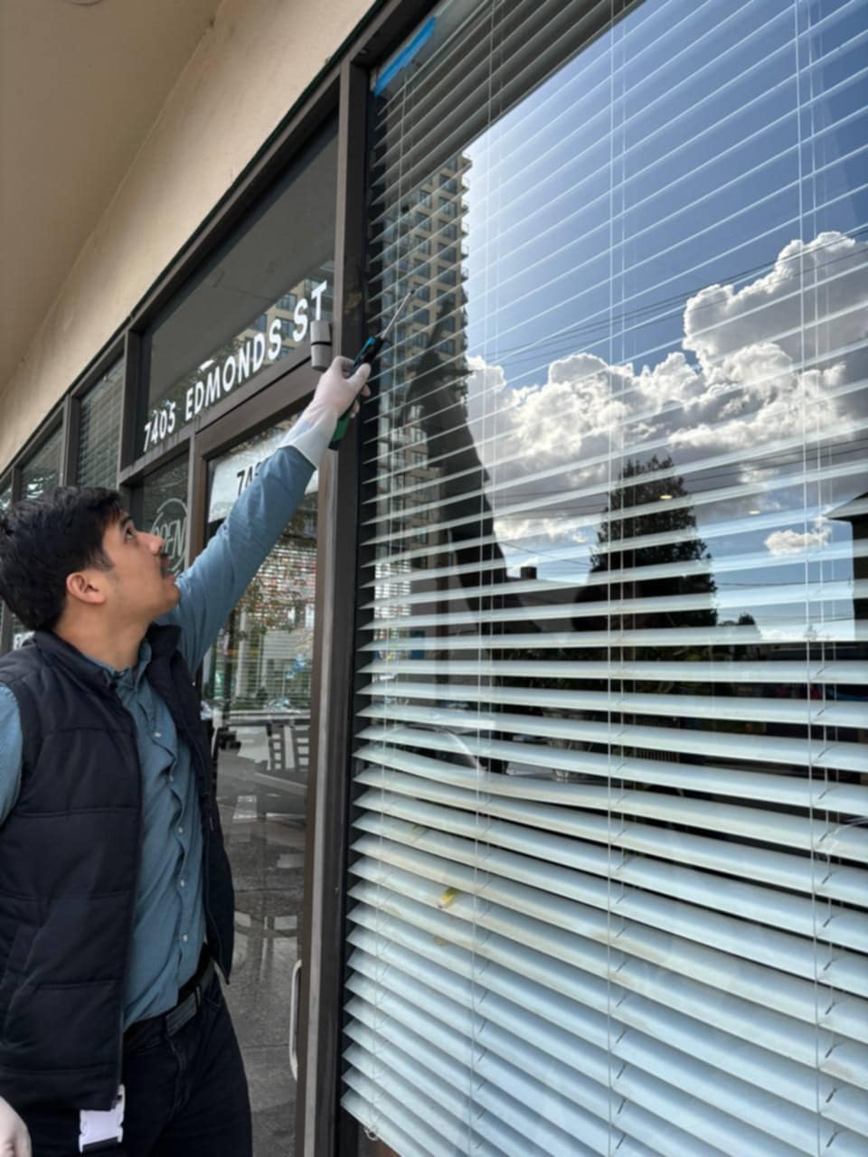 Cleaning the edge of storefront glass by hand